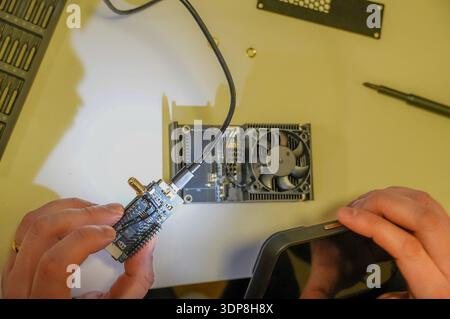 Technician repairing the computer with a screwdriver, close-up Stock Photo