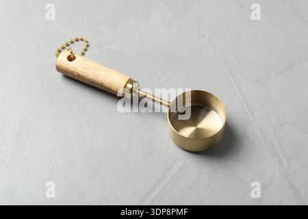 Golden scoop on gray textured table, closeup Stock Photo