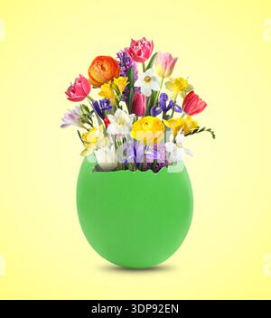 Easter card with spring flowers in broken eggshell on beige background Stock Photo