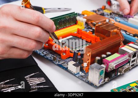 Engineer checking motherboard with multimeter Stock Photo