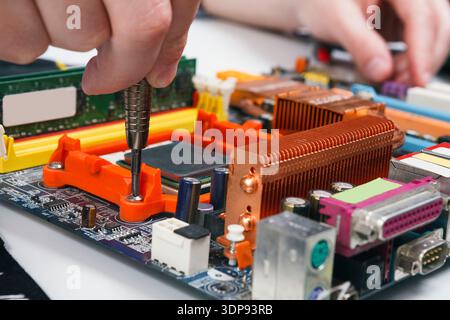 Engineer checking motherboard with multimeter Stock Photo