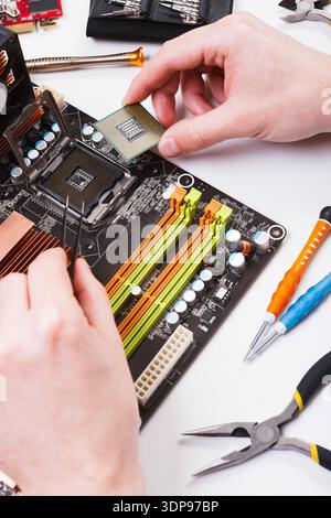 Technician plug in microprocessor to motherboard Stock Photo