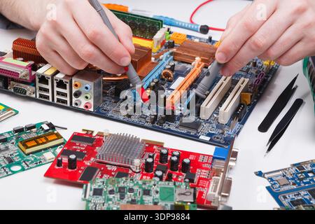 Engineer checking motherboard with multimeter Stock Photo