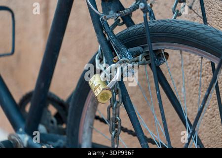 Bicycle wheel locked with chain and padlock anti theft security Stock Photo