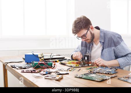 Man Working on Electronic Circuit Boards in a Bright Indoor Space During the Day Stock Photo