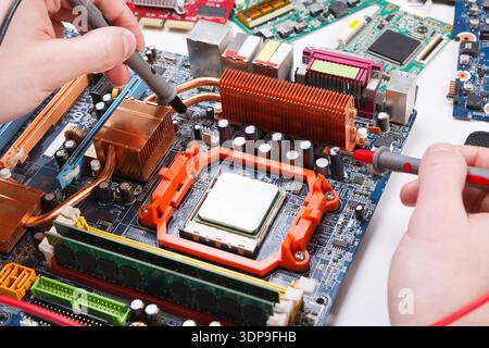 Engineer checking motherboard with multimeter Stock Photo