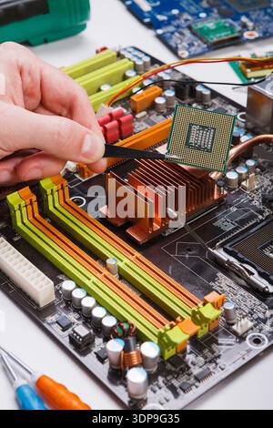 Technician plug in microprocessor to motherboard Stock Photo