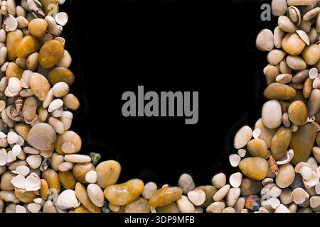 Seashells and pebbles on black background, natural seashore stones Stock Photo