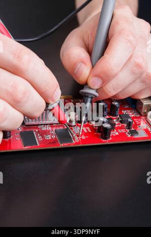 Electronic circuit red board inspecting close up Stock Photo
