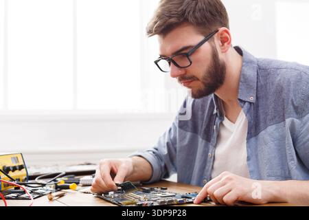 Changing Components on a Circuit Board in a Workshop During Daylight Hours Stock Photo