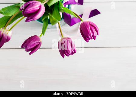 Purple Tulips in a Vase With Ribbon on a Light Wooden Table During Daytime Stock Photo