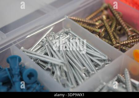 Various types of metal fasteners in a storage box Stock Photo