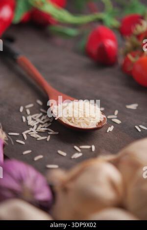 Rice and veggies on a wooden table in a kitchen Stock Photo