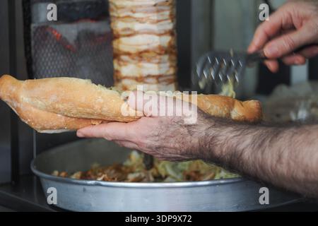 Street Doner Kebab Sandwich Being Prepared by Vendor Handheld Baguette Sandwich  Stock Photo
