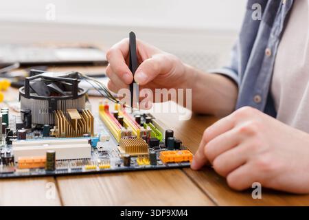 Person Works on Computer Motherboard With Tools in a Workshop During Daytime Stock Photo