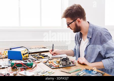 Someone Working on Computer Circuit Boards in a Bright Workshop During the Day Stock Photo