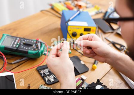 Repairing Electronic Components With Tools on a Workbench in a Workshop Environment Stock Photo