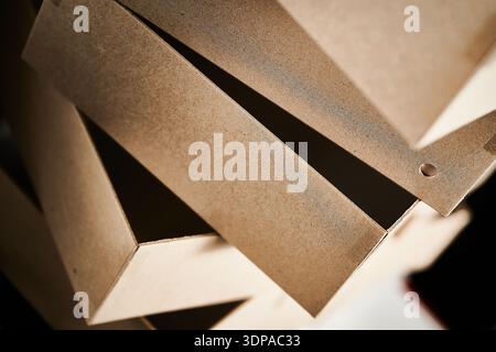 Cardboard box blanks stacked in a cardboard box manufacturing facility ready for assembly and packaging in the production process Stock Photo