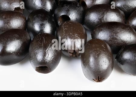 Macro black olives showcasing glossy texture and subtle highlights, tight crop on clustered pitted fruits, minimalist composition for packaging or edi Stock Photo