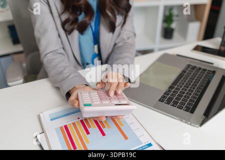 Professional businesswoman reviewing performance reports in a modern office, analyzing results and planning next steps to improve strategy, productivi Stock Photo