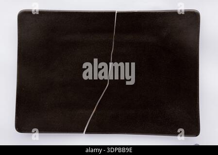 Broken black plate Stock Photo