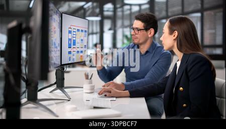 Diverse Team Of Designers Using Computers For UI/UX Development. Flight Attendant Providing Training Stock Photo