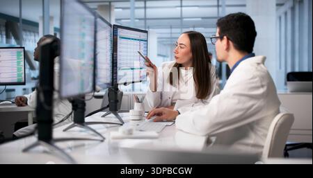 Medical Professionals Utilizing Advanced Technology To Analyze Patient Data In Hospital. Stock Photo