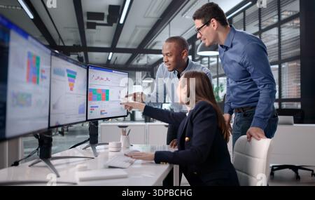 Celebrating With Colleagues As Woman Monitors KPI Traffic Spike On Dashboard. Possible Professions: Business Analyst Stock Photo