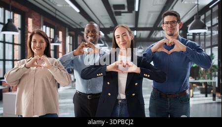 African-American Man And Hispanic Woman Building Team Unity With Heartgesture Stock Photo