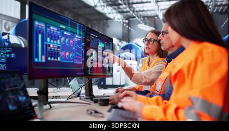 Modern SCADA Room: Engineers Meeting Maintenance Operator At Control Panel Stock Photo