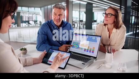 Multicultural Financial Analysts Meet To Discuss Key Performance Indicators. Stock Photo