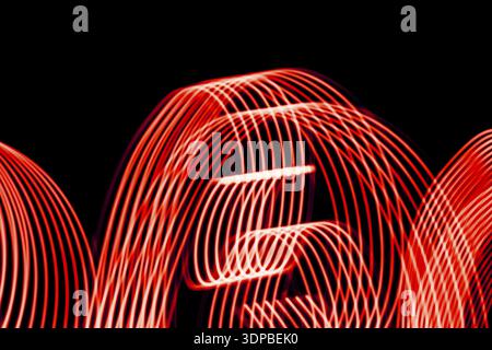 Bright red spiral patterns from light strips on a black background Stock Photo