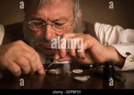 Closeup image of a Victorian watchmaker working on an antique pocket watch Stock Photo