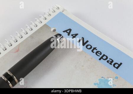 A4 Notepad and black pen on white background placed diagonally Stock Photo