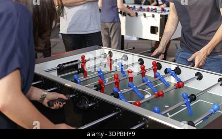 Unrecognizable people enjoying a game of table soccer. No faces shown Stock Photo
