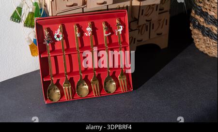 Christmas Themed Spoons and Forks tableware set on black. Gift red box Stock Photo