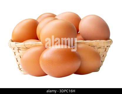 Many brown chicken eggs in stack in wicker basket are isolated on white background with clipping path. Stock Photo