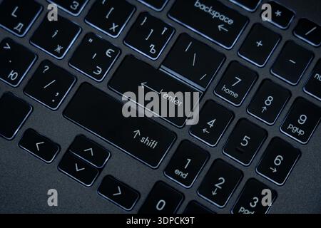 A close view shows a computer keyboard with keys highlighted. The symbols and letters are visible. Users can see the layout of the keys. Stock Photo