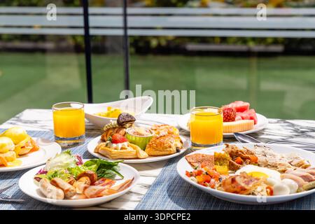 Luxurious breakfast spread on marble table by window includes pastries Stock Photo