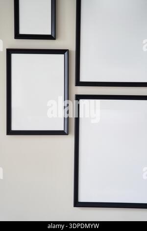Different size framed photos hanging on the gray wall. Mockup. Stock Photo