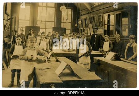1900s post WW1 / 1920's school children in wood working class, Master.  1900's School boys learning to use tools - Saws, hammers, set square, UK Stock Photo