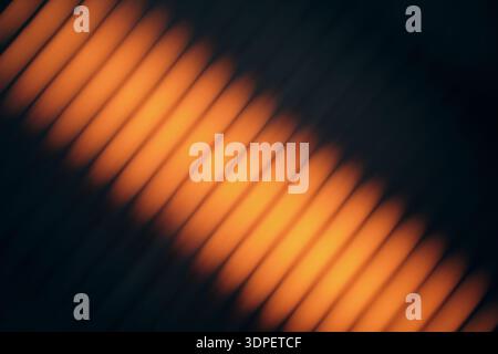 Orange light creating blurry diagonal line pattern on dark background Stock Photo
