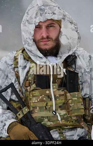 Winter Soldier Portrait Wearing Snow Camouflage And Tactical Vest With Serious Expression Stock Photo