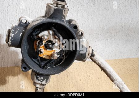 Close-up of an open electrical junction box with exposed copper wires, showing industrial wiring details, electrical installation and infrastructure m Stock Photo