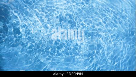 Bright blue water surface reflects light in a swimming pool on a sunny day in summer Stock Photo