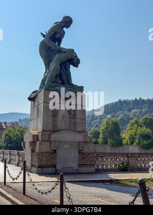 Allegorical bronze group on Ponte Umberto I in Turin, Italy, seen against hillside trees and clear summer sky in morning light. Stock Photo