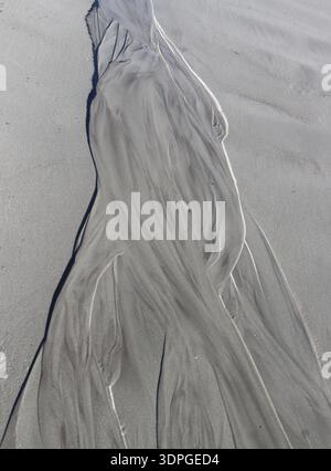 “Natural sand patterns created by flowing water on a beach in Midcoast Maine. Stock Photo