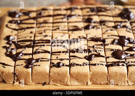 Homemade gluten free snack bars made with whey protein powder, almond flour, maple syrup, peanut butter and dark chocolate Stock Photo