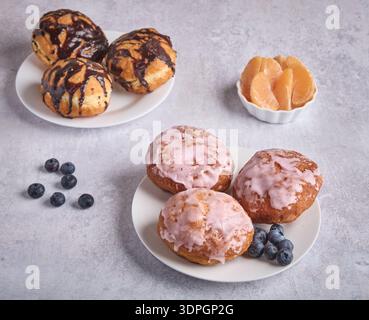 Assorted Glazed Donuts with Blueberries and Tangerine Stock Photo