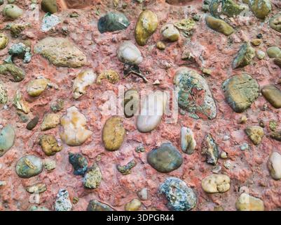 A restorative and tactile study of a pebble-dash wall at Pongratz Gergely ter. Smooth earthy stones in pink mortar create a grounded, serene urban aes Stock Photo